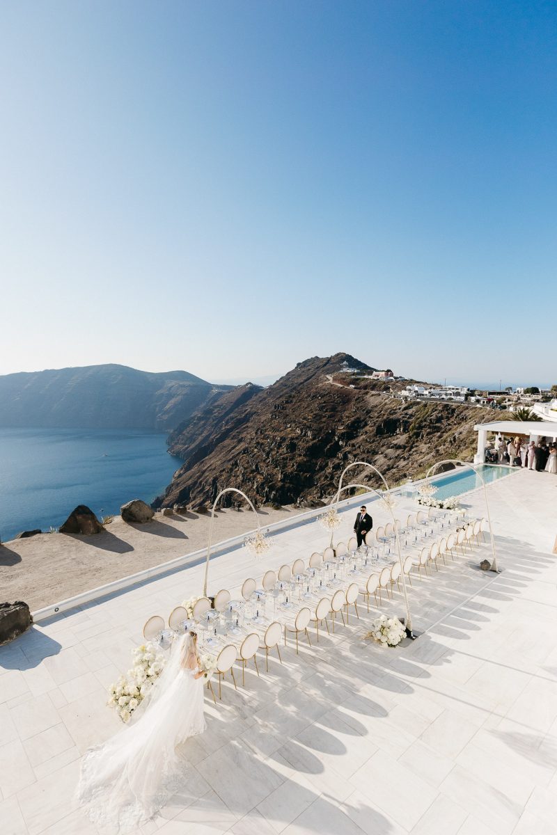 Bride and groom at luxury outdoor wedding reception in Santorini by Santorini wedding photographer