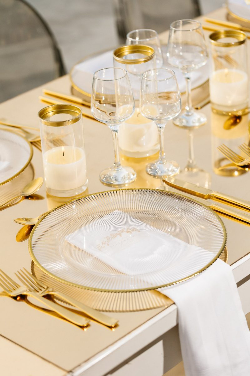 Santorini wedding photographer captures golden table setting with candles and glassware.
