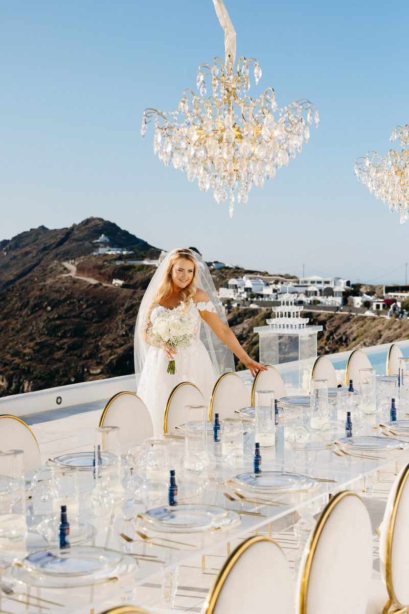 Bride by wedding reception table in Santorini captured by Santorini wedding photographer