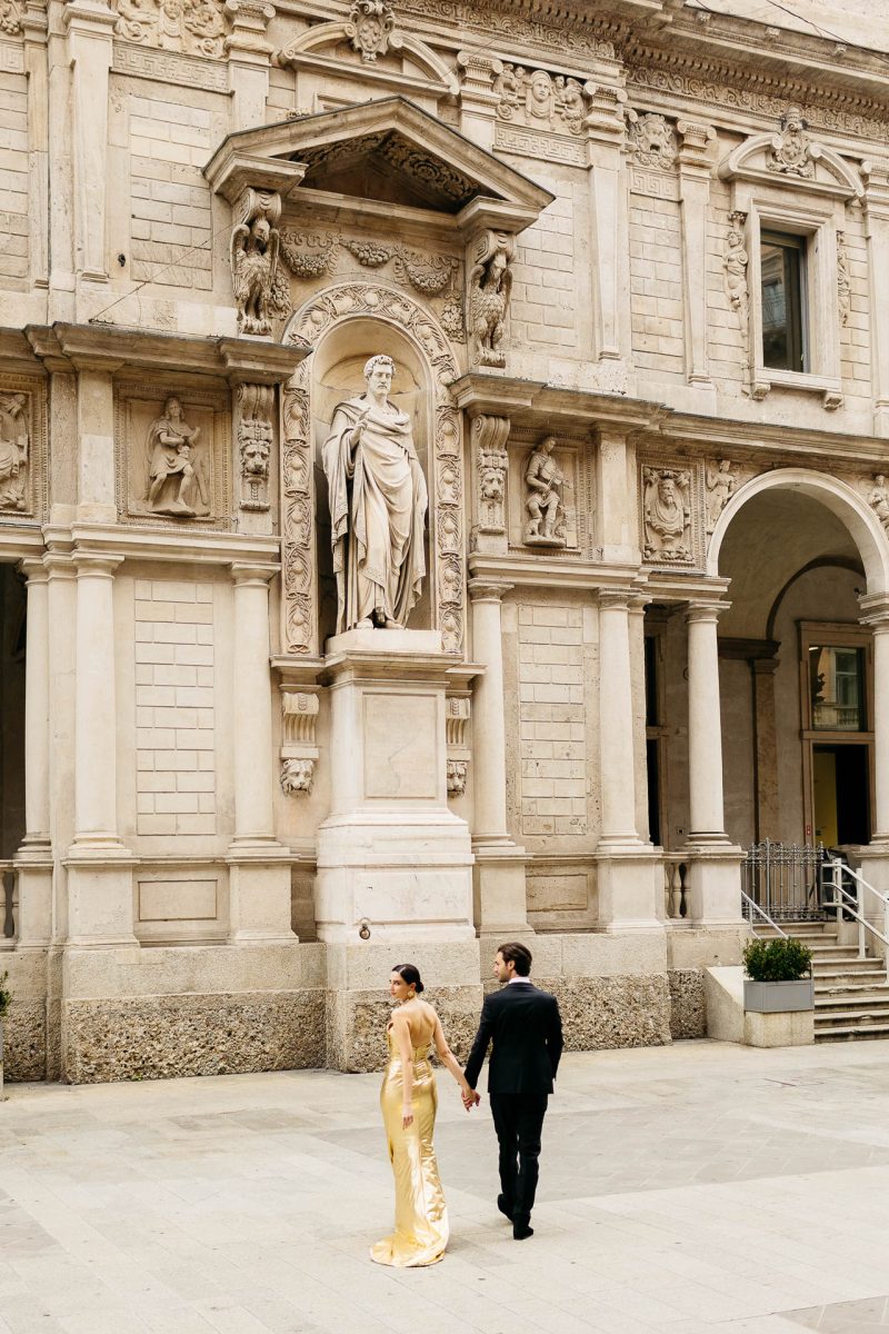 couple walking by sculpture santorini wedding photographer