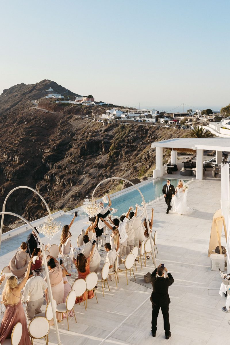 Bride and groom grand entrance at Santorini wedding by Santorini wedding photographer