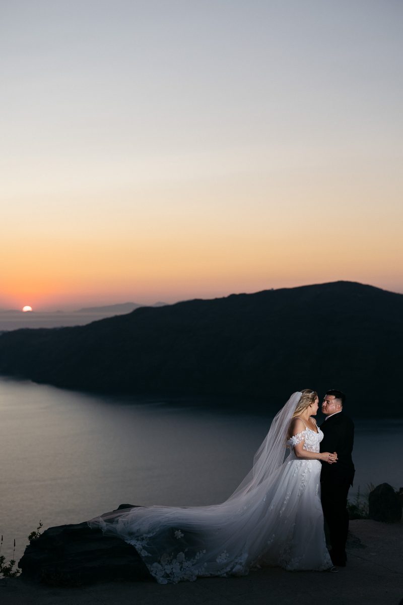Bride and groom sunset photo by Santorini wedding photographer