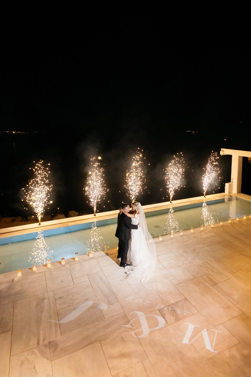 Bride and groom's first dance with fireworks by Santorini wedding photographer