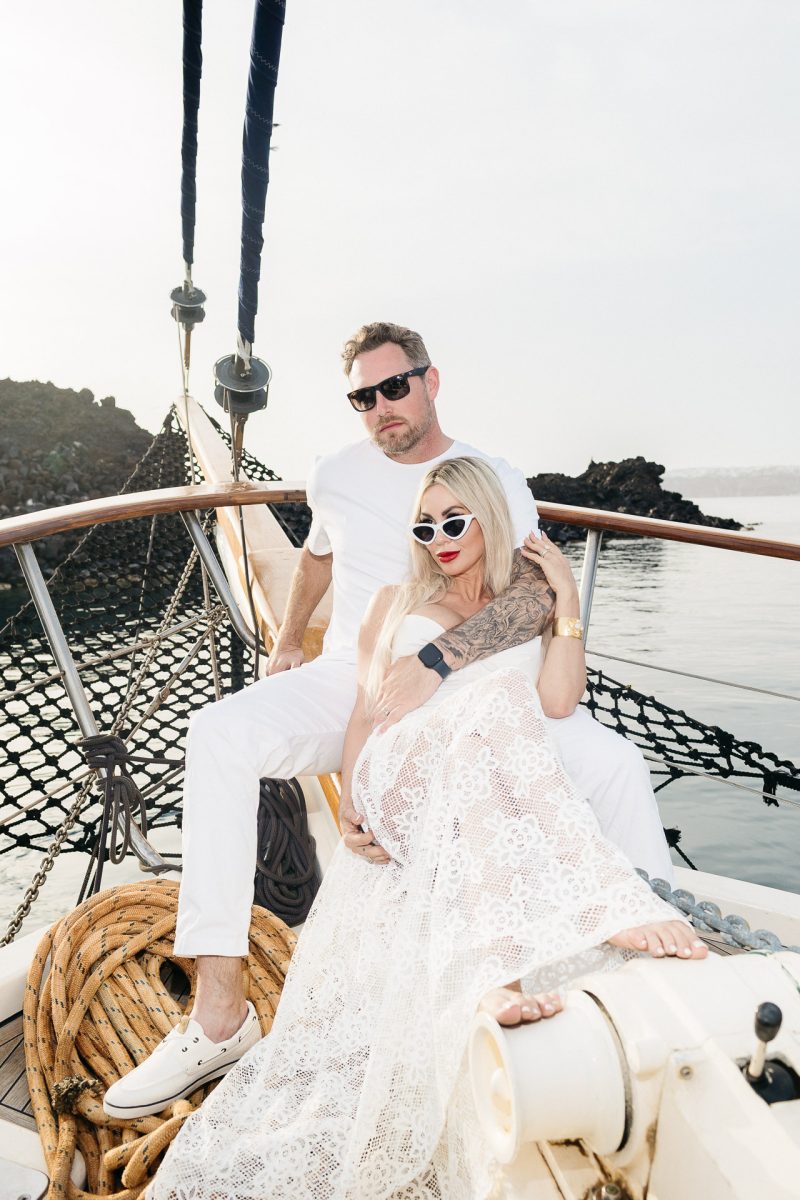 Bride and groom pose on a boat during a romantic Santorini wedding photoshoot