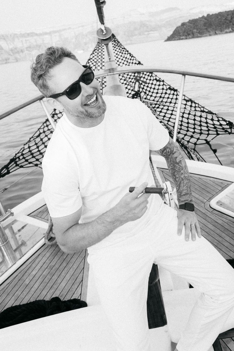 Groom enjoying a moment at sea, captured by a Santorini wedding photographer