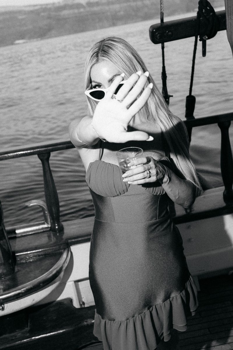 candid black-and-white photo of a guest on a Santorini wedding boat celebration