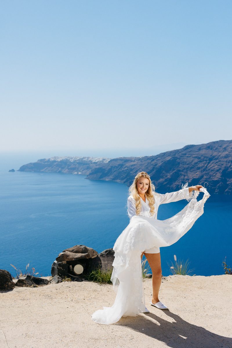 Bride holding wedding dress - Santorini wedding photographer