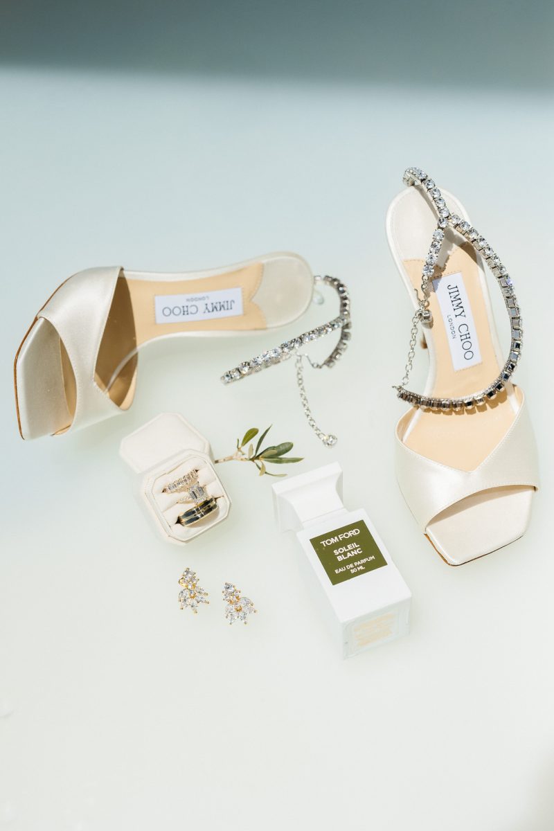 bridal flatlay with Jimmy Choo heels and rings by a Santorini wedding photographer