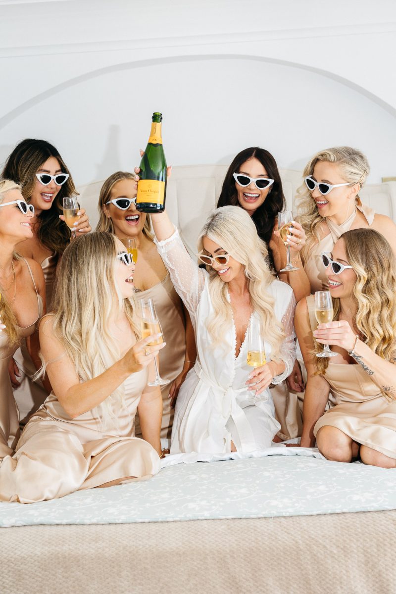 bride and bridesmaids toast with champagne in santorini