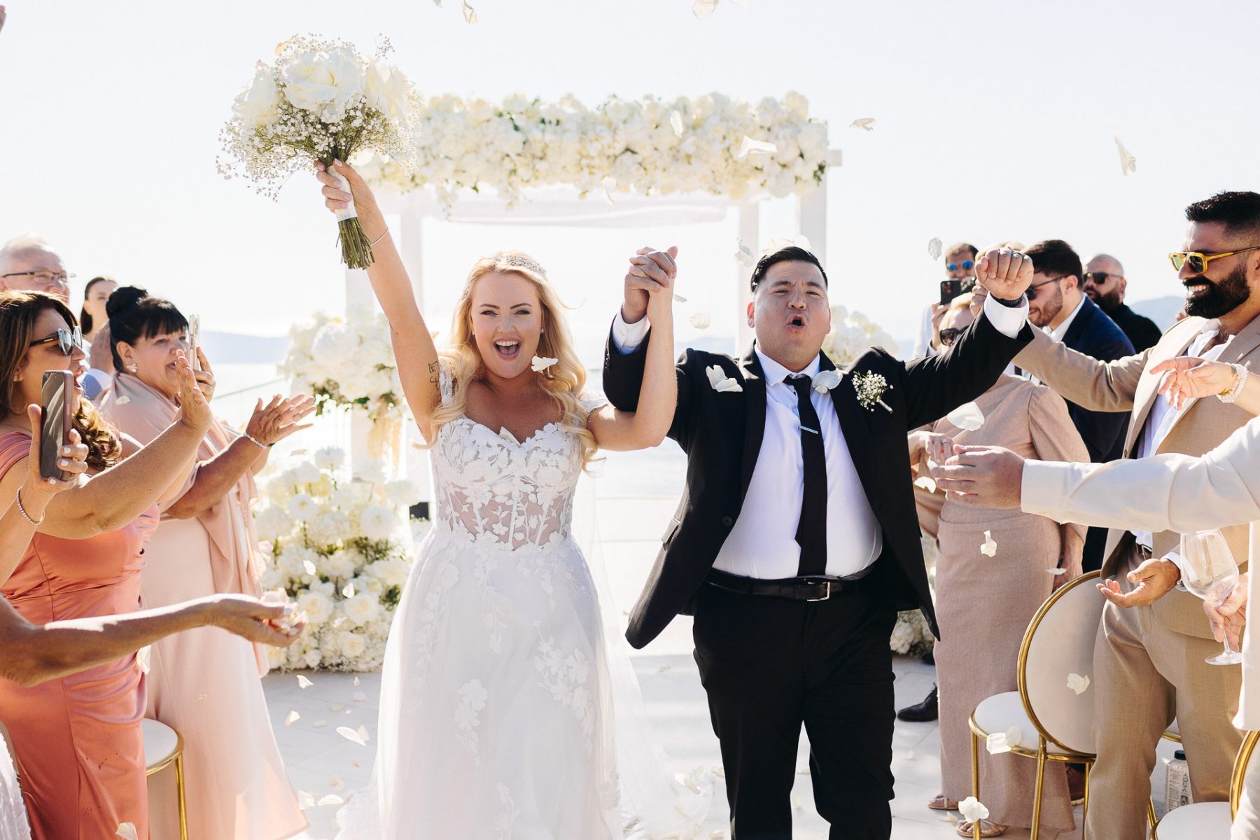 Santorini wedding photographer captures joyful bride and groom exit